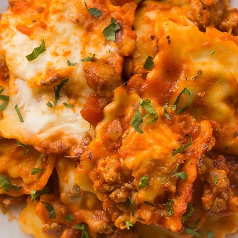 Baked ravioli with melted cheese, meat sauce, and fresh parsley from San's Pizza.